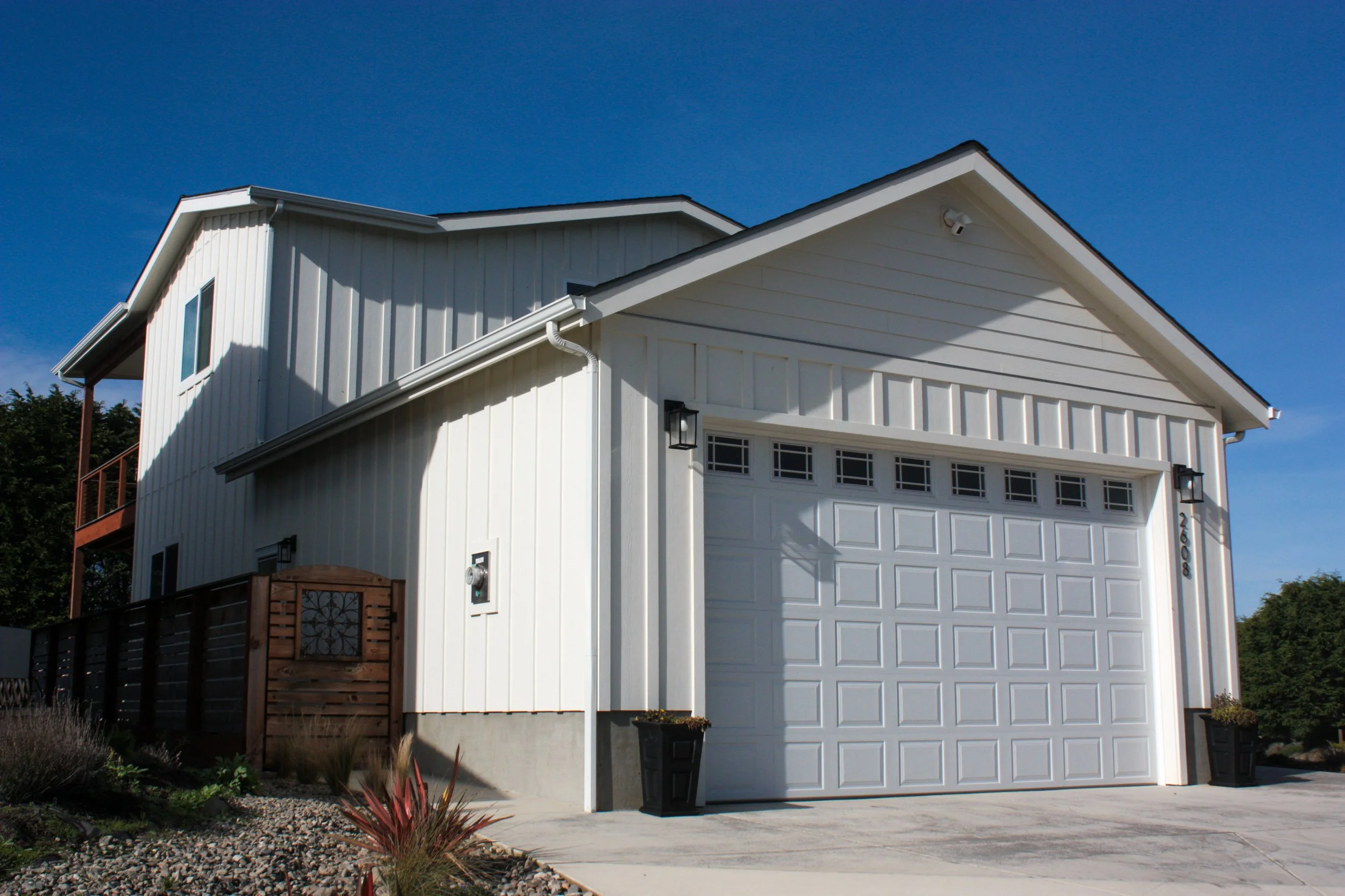 Modern white house with a garage and a blue sky.