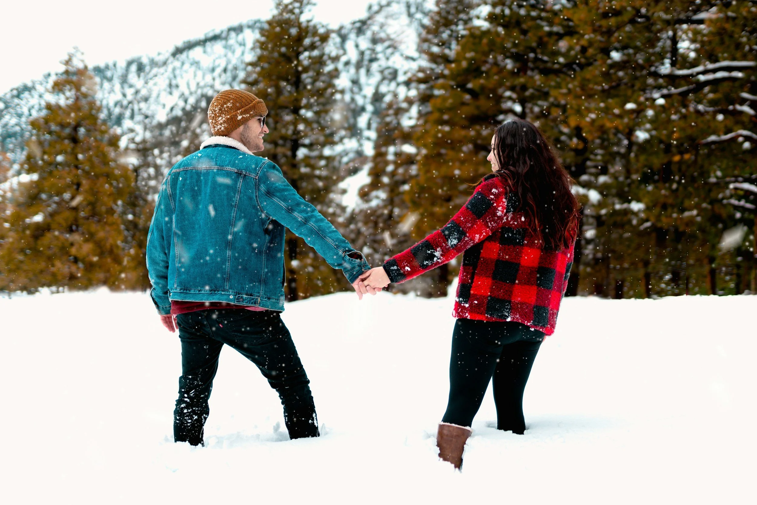A couple holding hands in a snowy landscape, with trees in the background, during winter.  Image is used to promote CouplesTherapy.co social media pages with the handle @couplestherapy.co.