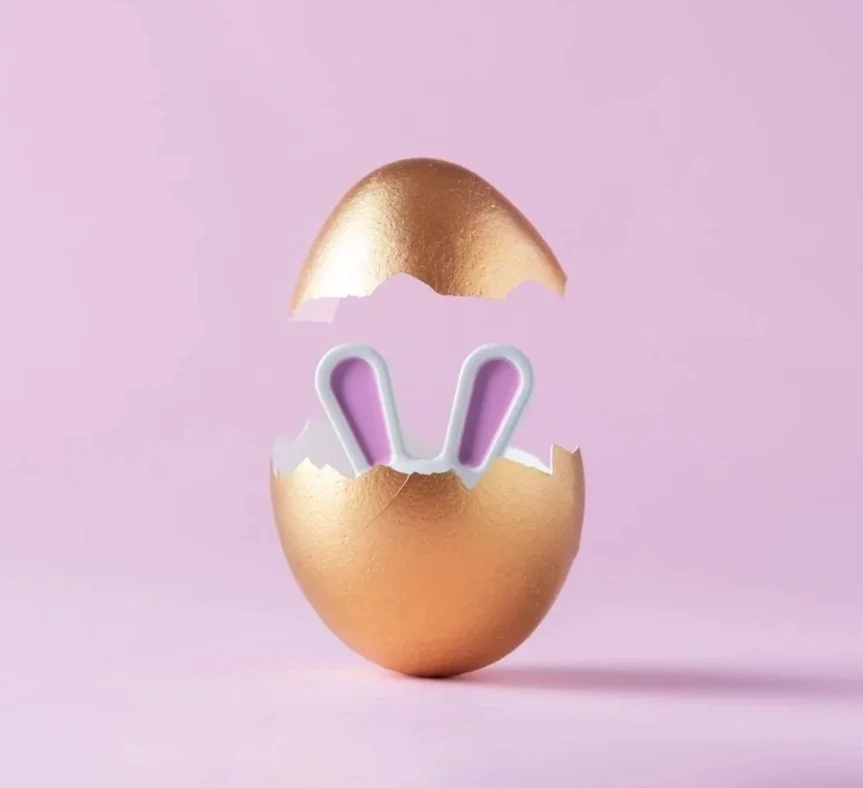 A young couple sitting on a leather sectional couch with a brick wall behind them, smiling and holding mugs, celebrating Christmas with holiday socks & decorations in the living room. Image is used for our CouplesTherapy.co Relationship Skills CLASS.