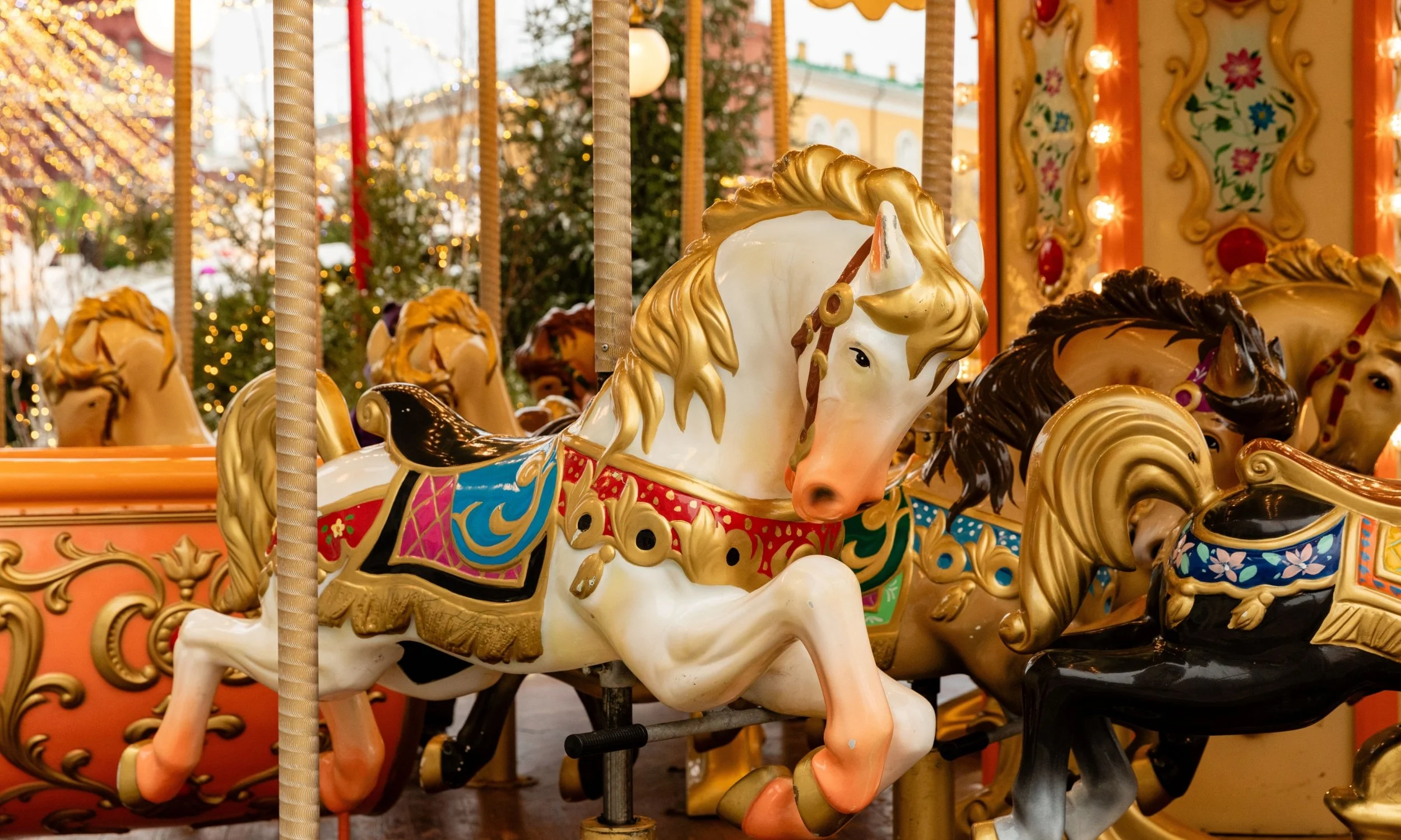 A happy couple celebrating at a restaurant, looking at a laptop together with holiday lights in the background. Image is used for our CouplesTherapy.co Relationship Skills CLASS™ in December.