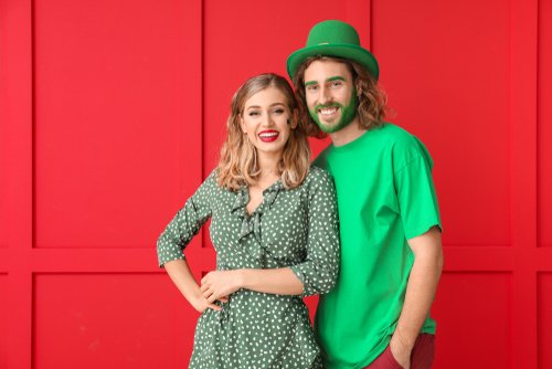 A cherry with a green stem and a mirrored disco ball heart on a bright pink background.