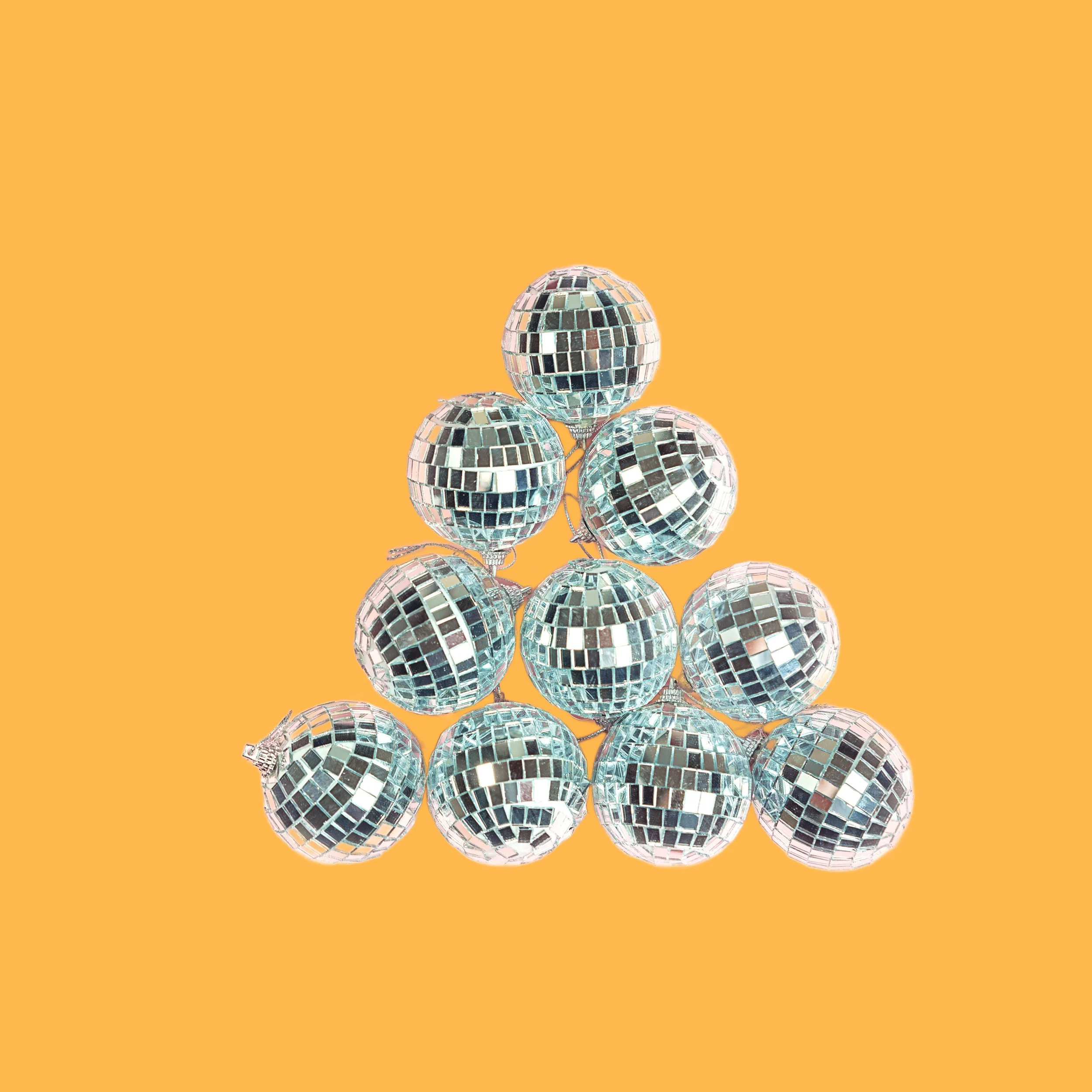 Stacked silver disco balls arranged in a triangular pyramid on an orange background. Image for The Relationship Skills CLASS™ at CouplesTherapy.co.