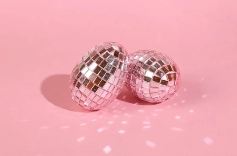 A happy couple celebrating at a restaurant, looking at a laptop together with holiday lights in the background. Image is used for our CouplesTherapy.co Relationship Skills CLASS™ in December.