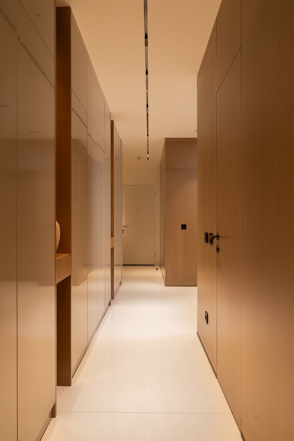 Platsbyggd hallförvaring i skräddarsydd design med integrerade paneler och minimalistiskt uttryck.