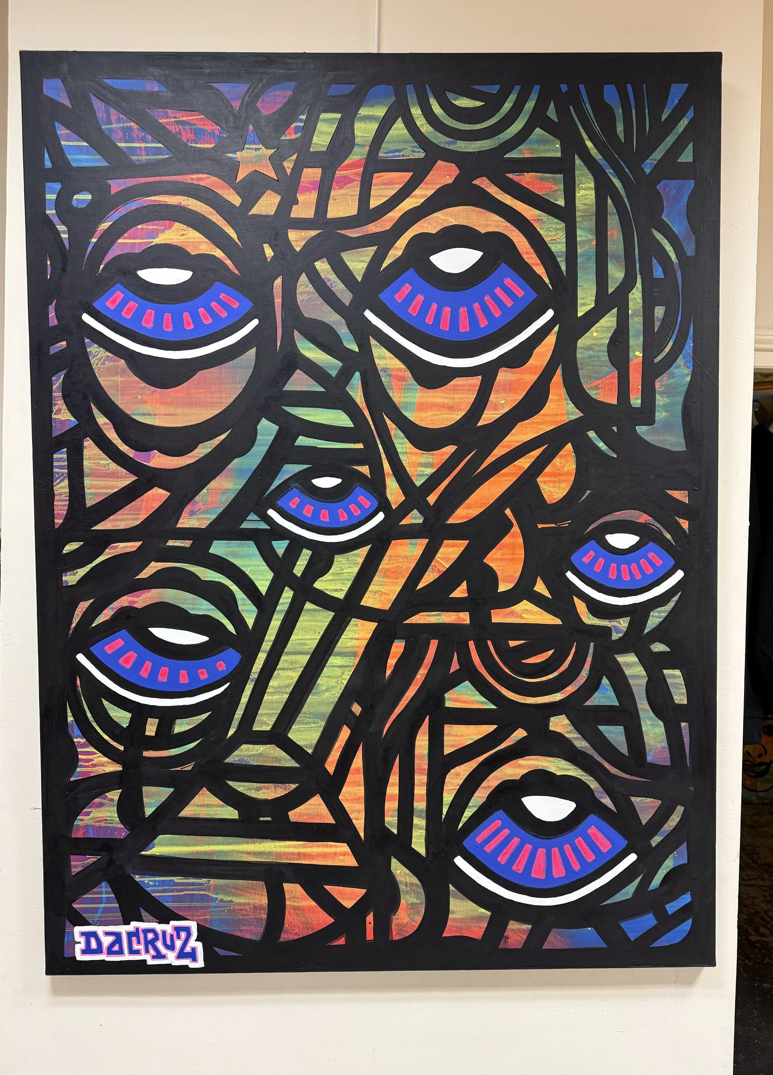 Peinture abstraite avec des contours noirs, des visages stylisés avec des yeux en forme d'ailes bleues avec des lignes roses, et un fond coloré en dégradé de vert, orange, violet et autres couleurs.