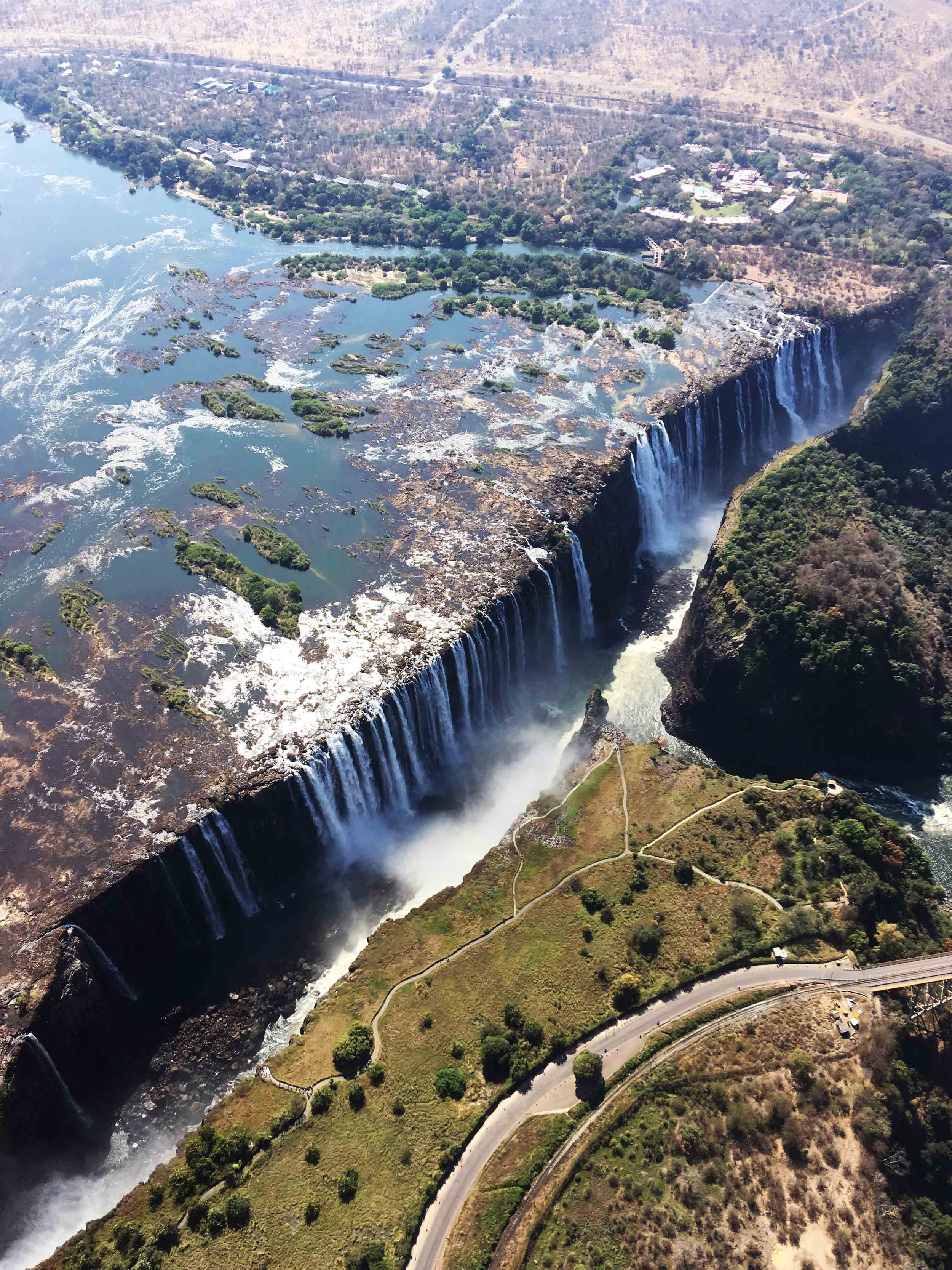 Cascade Victoria, frontière de la Zambie et du Zimbabwe, vue du ciel avec la rivière, la végétation et les routes environnantes.
