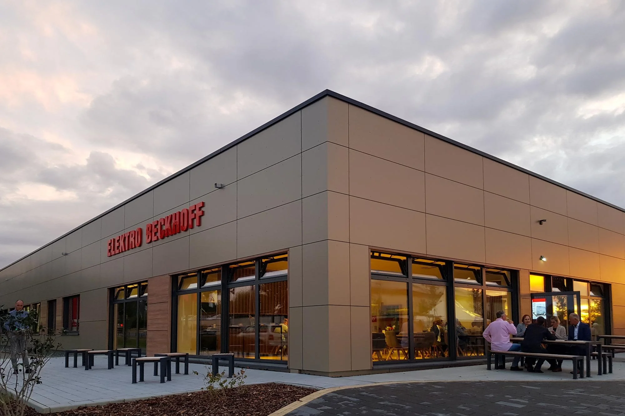 Modernisierte Halle mit Eternit-Fassade und großen Fensterflächen im Bestand
