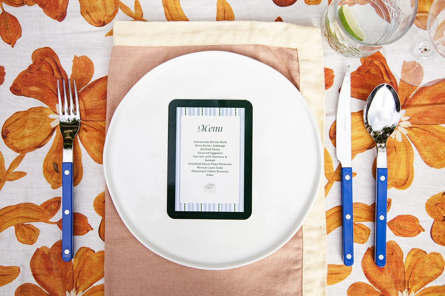 place setting on a dinner table with blue sabre cutlery and linen napery
