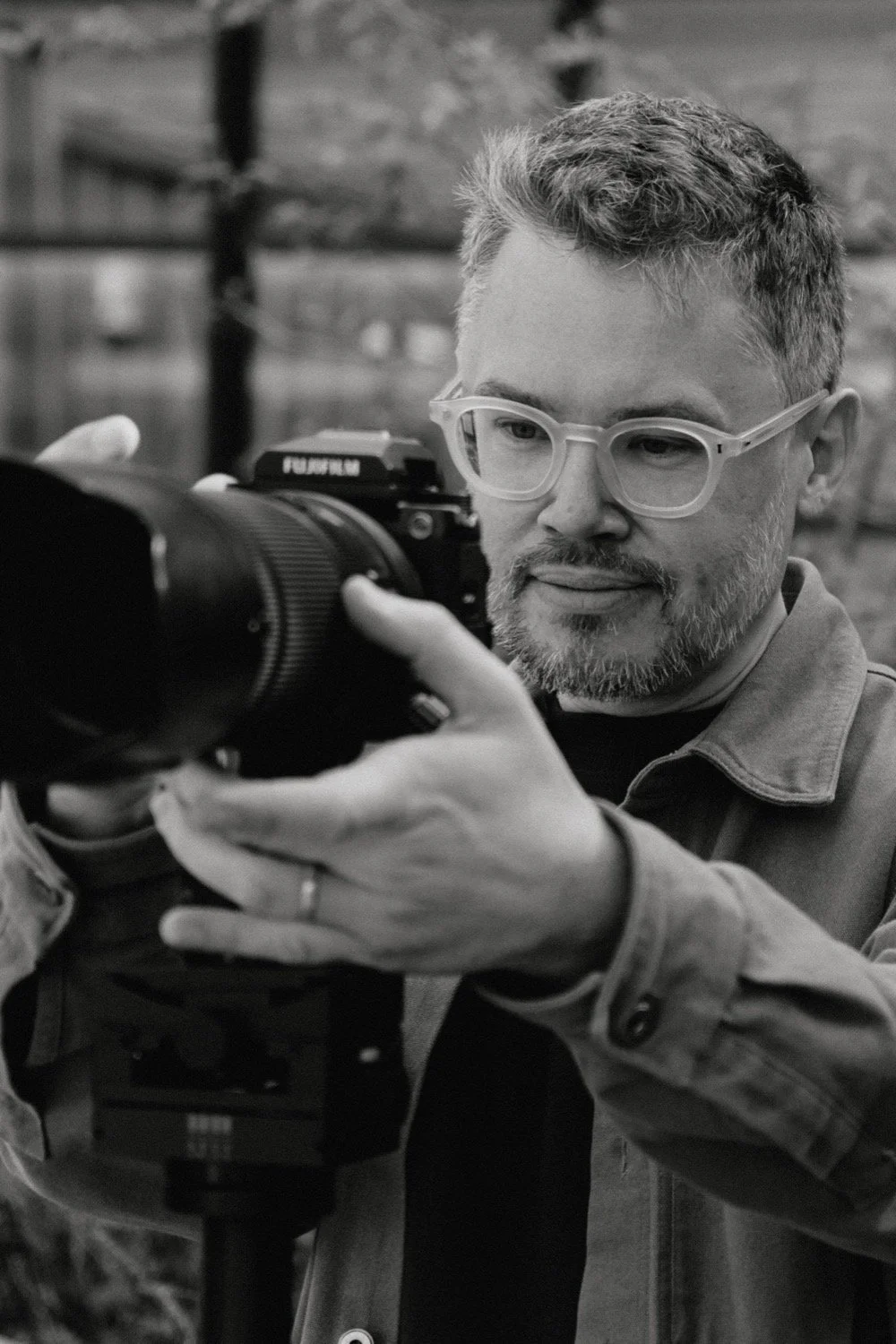 Black and white close-up of architectural photographer Matthew Smith with his camera