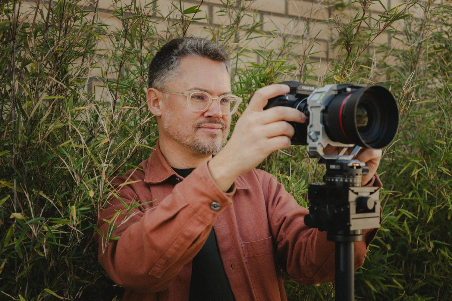 Portrait of Matthew Smith, architectural photographer, framing a shot among bamboo planting