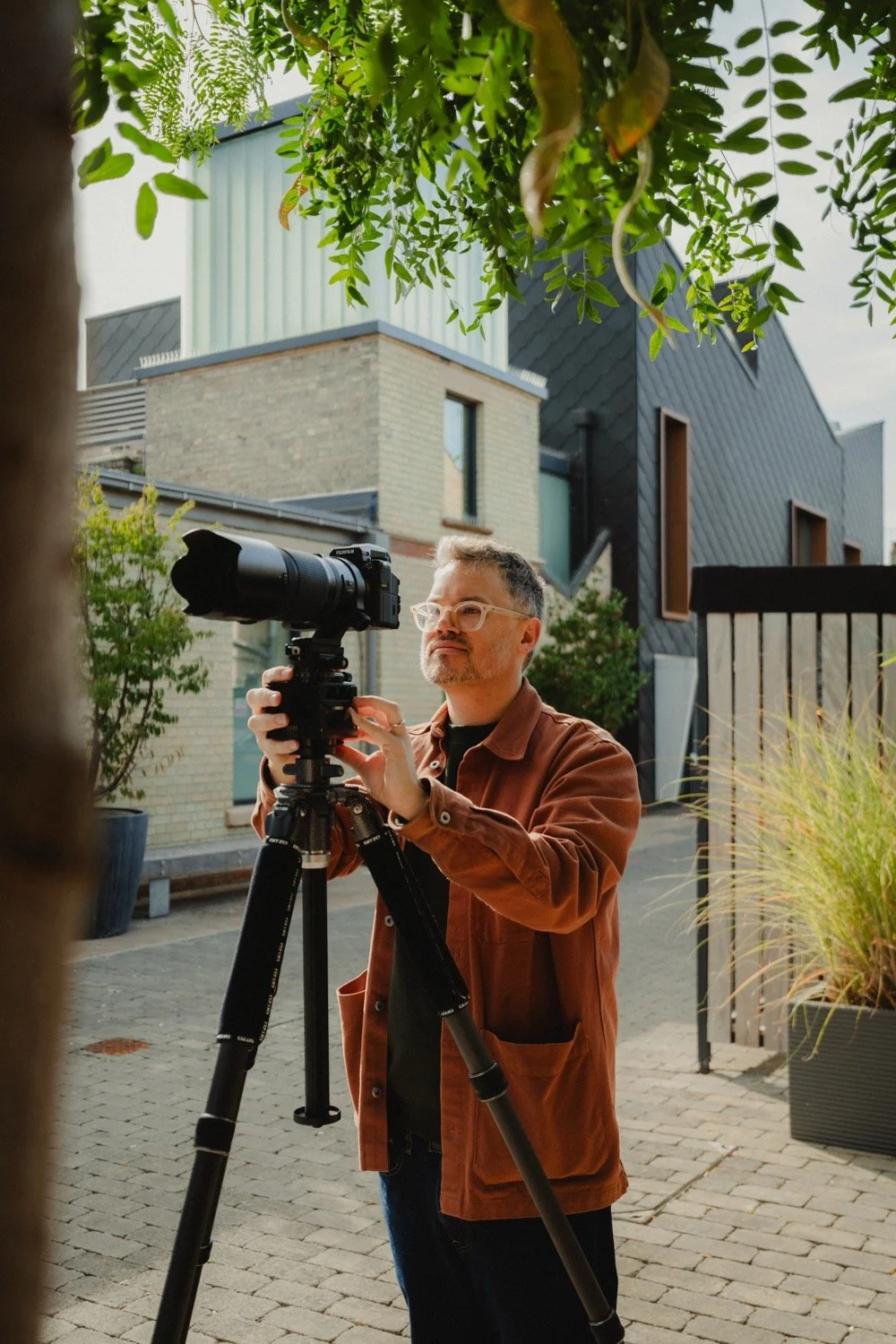 Architectural photographer Matthew Smith adjusting his camera on a tripod at Old Swiss, Cambridge
