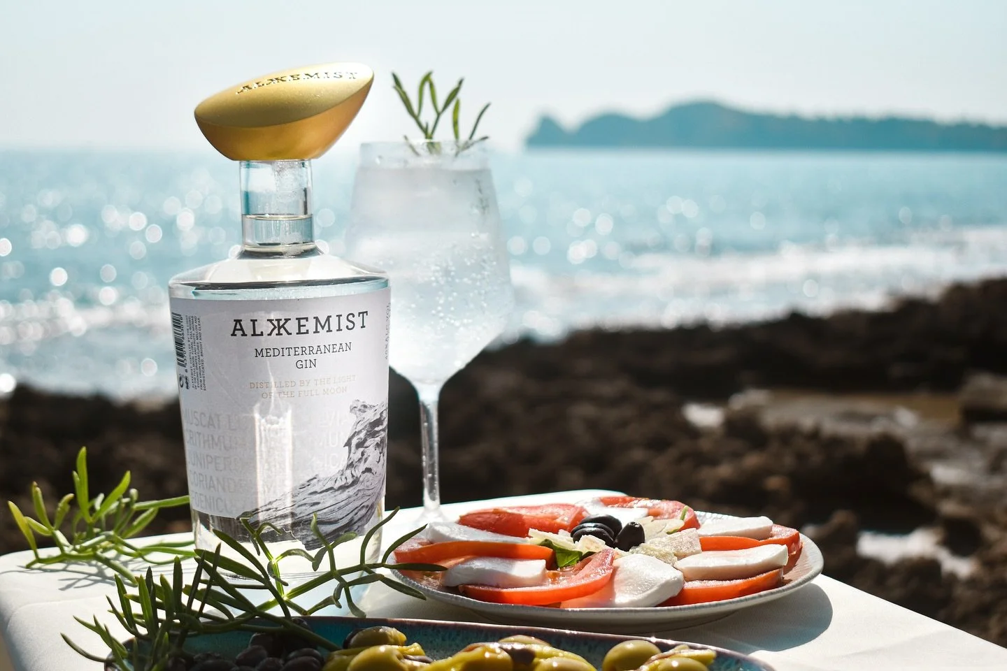 Afternoons taste better by the Mediterranean.
Ice, sea fennel, golden light &mdash; and a gin that makes it all hit different.

Alkkemist Gin.
21 botanicals. Distilled under the full moon.
Best served when the sun goes down&hellip; and the glass goes