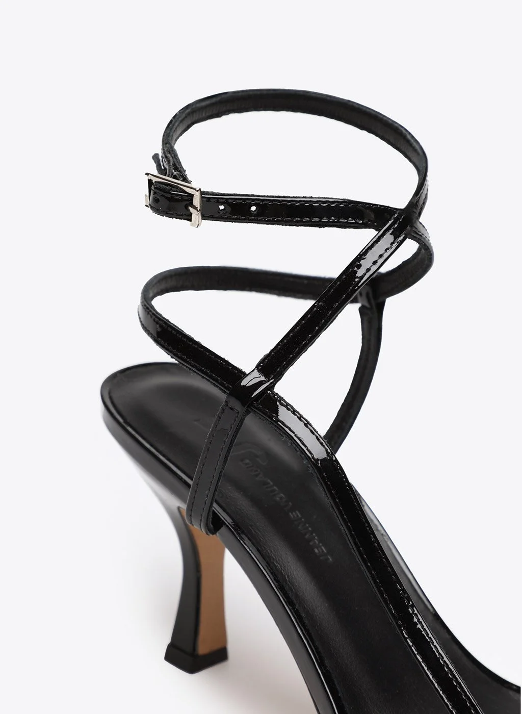Sandale à talon haut noires en cuir avec des brides fines et une boucle à l'avant, vue rapprochée.
