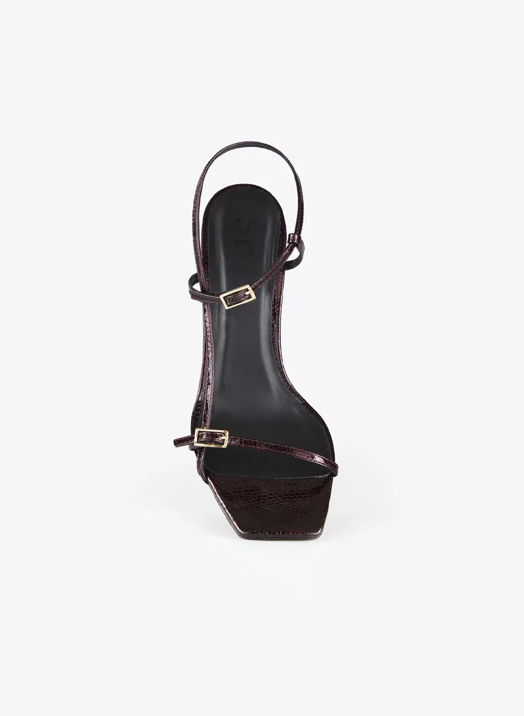 Une chaussure à talon haut en cuir verni de couleur bordeaux avec deux brides à boucle en or.