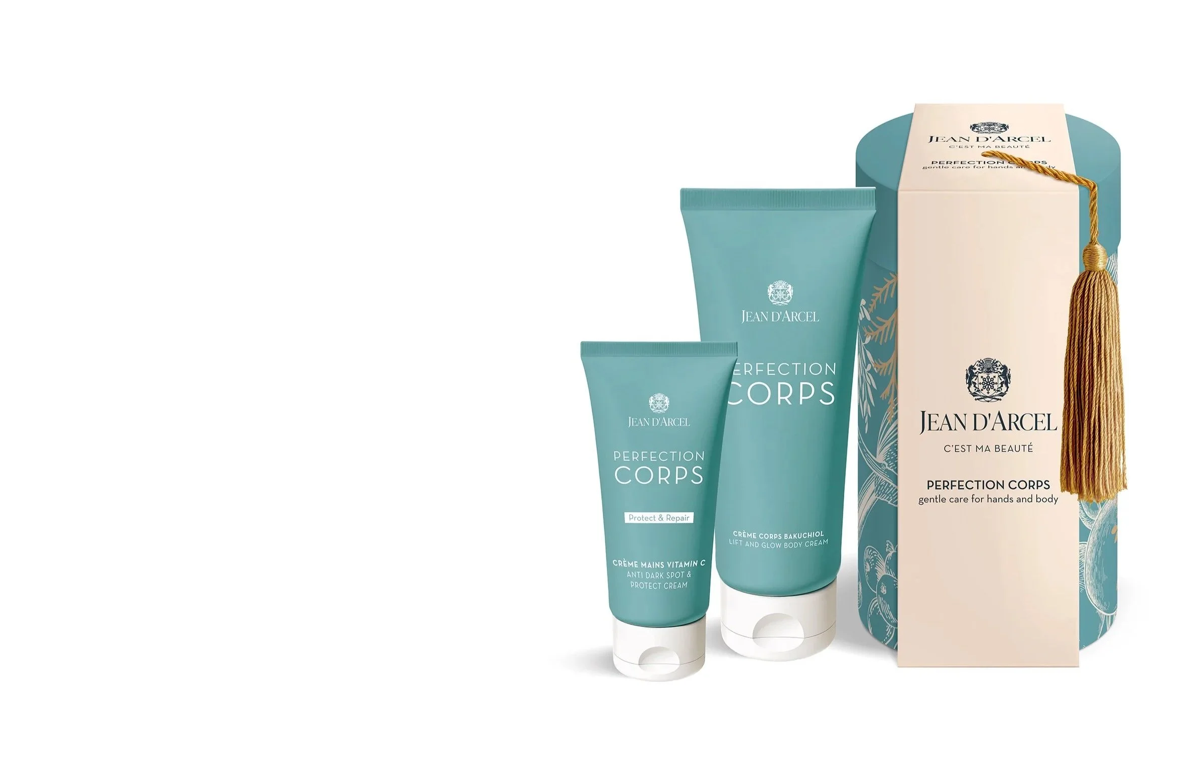 Zwei blaue Tuben von Jean d'Arcel Perfection Corps, eine größere und eine kleinere, stehen neben einer dekorativen Verpackung mit einem goldenen Quaste, die Produkte sind für Hand- und Körperpflege.