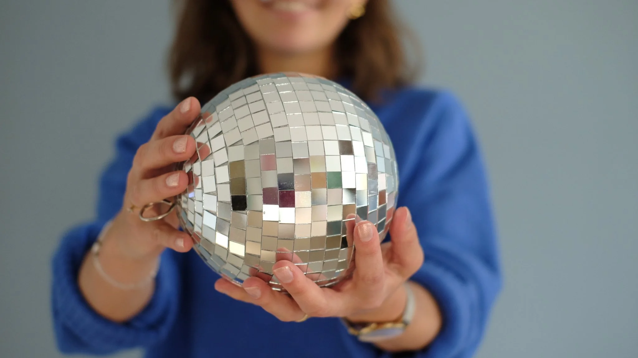 Hände halten Diskokugeln als Symbol für mehr Lebensfreude und Gelassenheit durch Coaching in Aachen