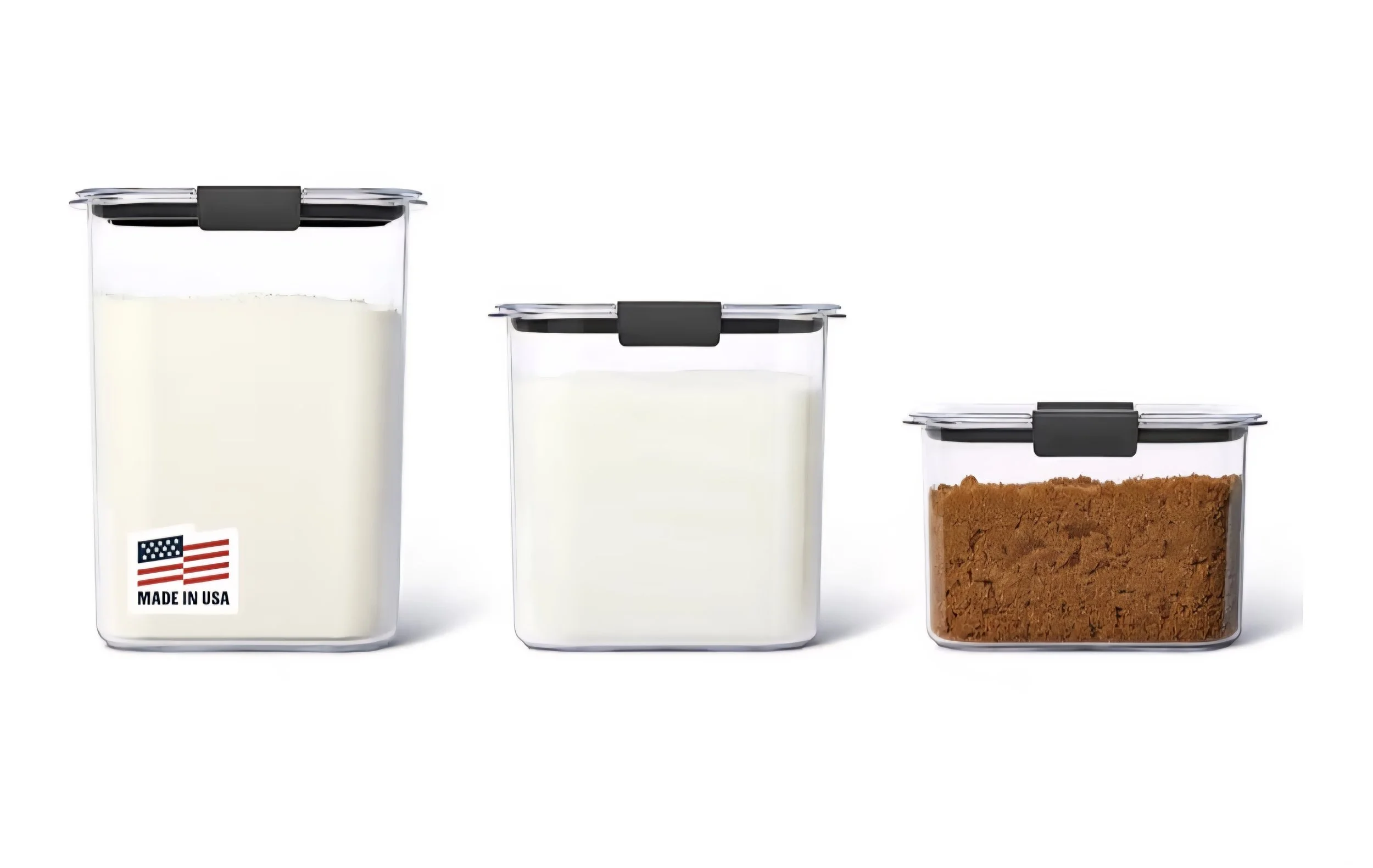 Three clear plastic storage containers with black lids, filled with milk and ground spices.