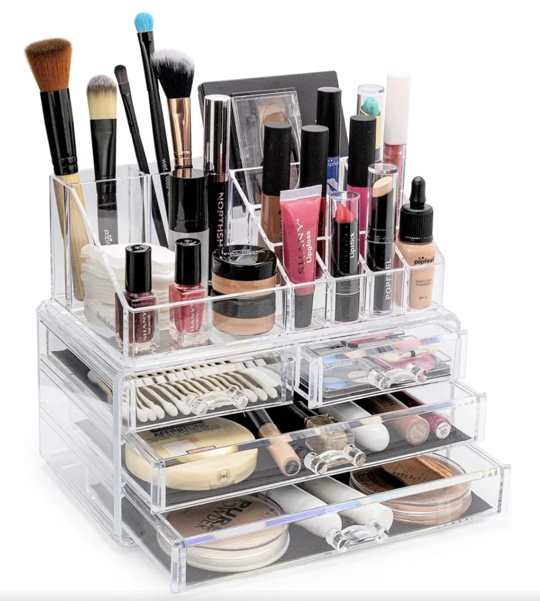 A clear acrylic makeup organizer filled with various makeup brushes, lipsticks, lip glosses, foundations, powders, and makeup accessories.