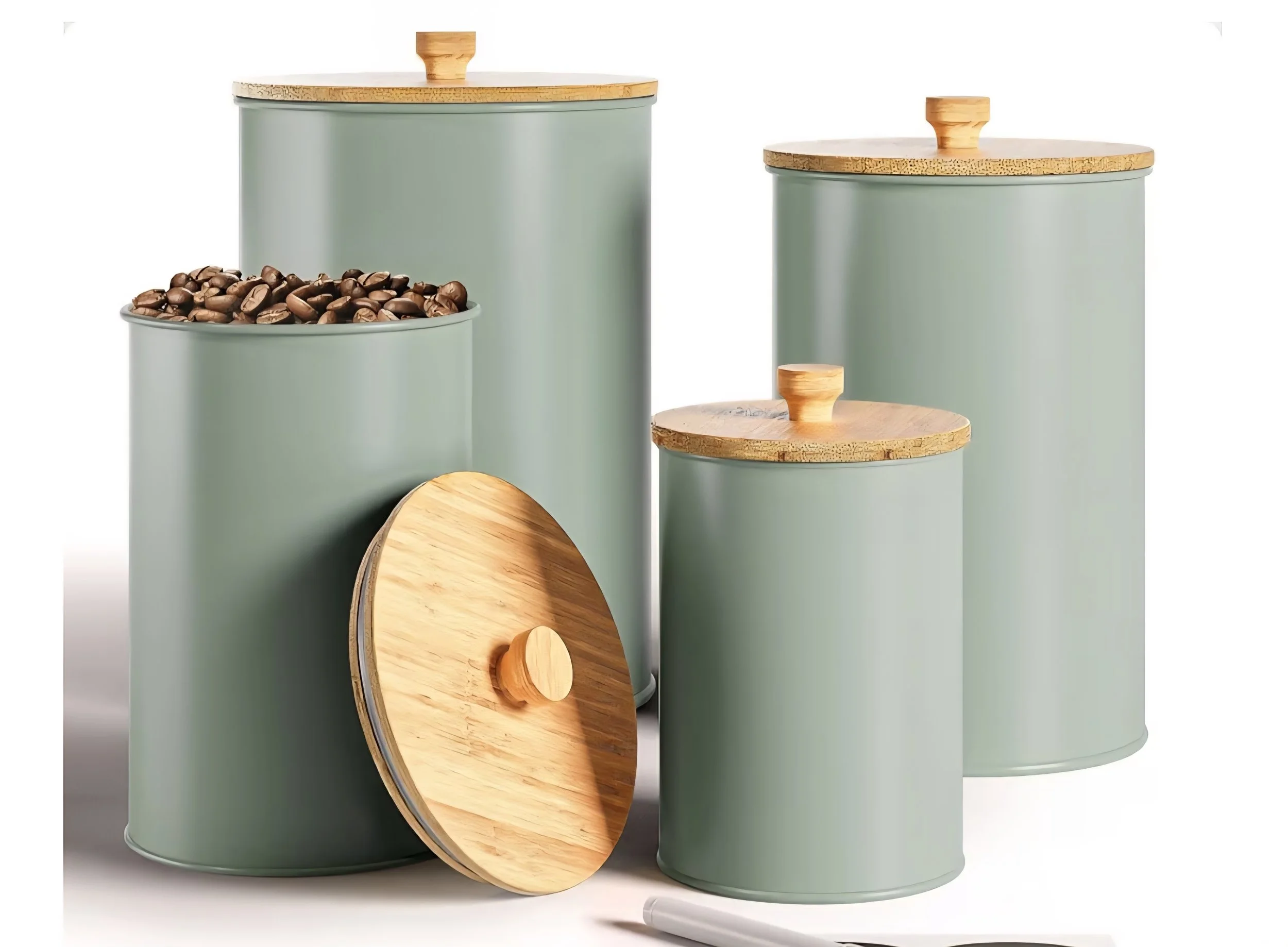 Set of four green kitchen canisters with wooden lids, one filled with coffee beans, two different sizes, and a rolling pin.