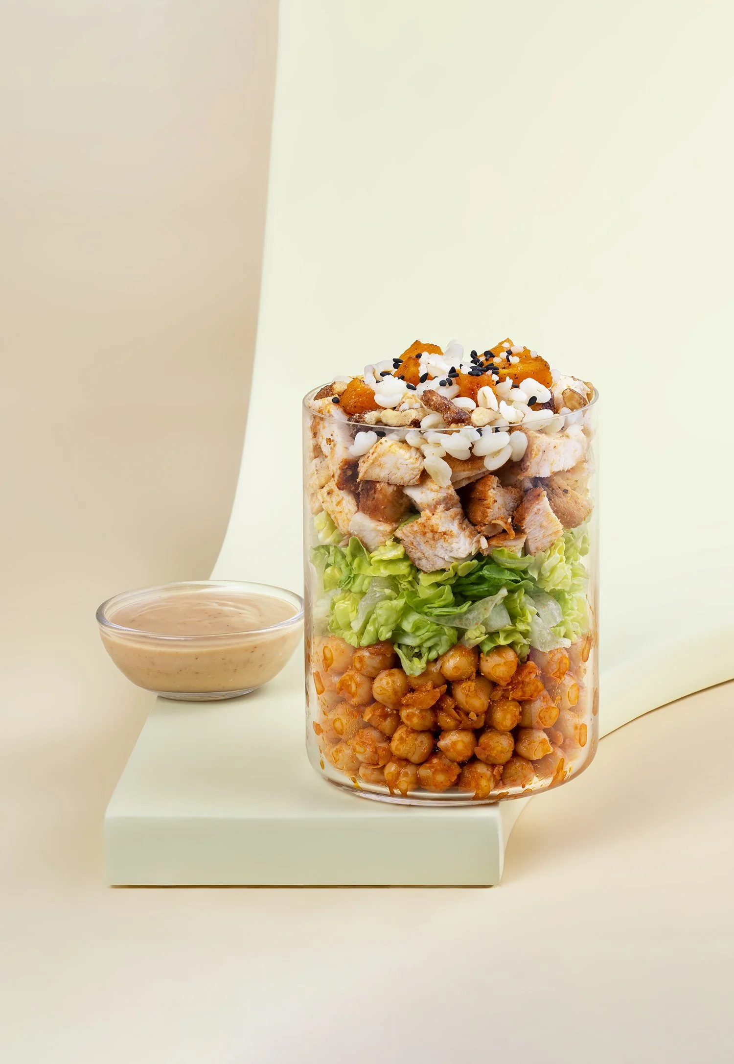 Layers of chopped chicken, lettuce, chickpeas, and other salad ingredients