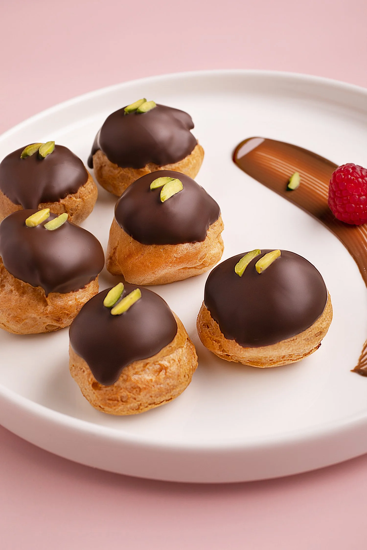Six cream puffs topped with chocolate and pistachio Food photography in Kuwait