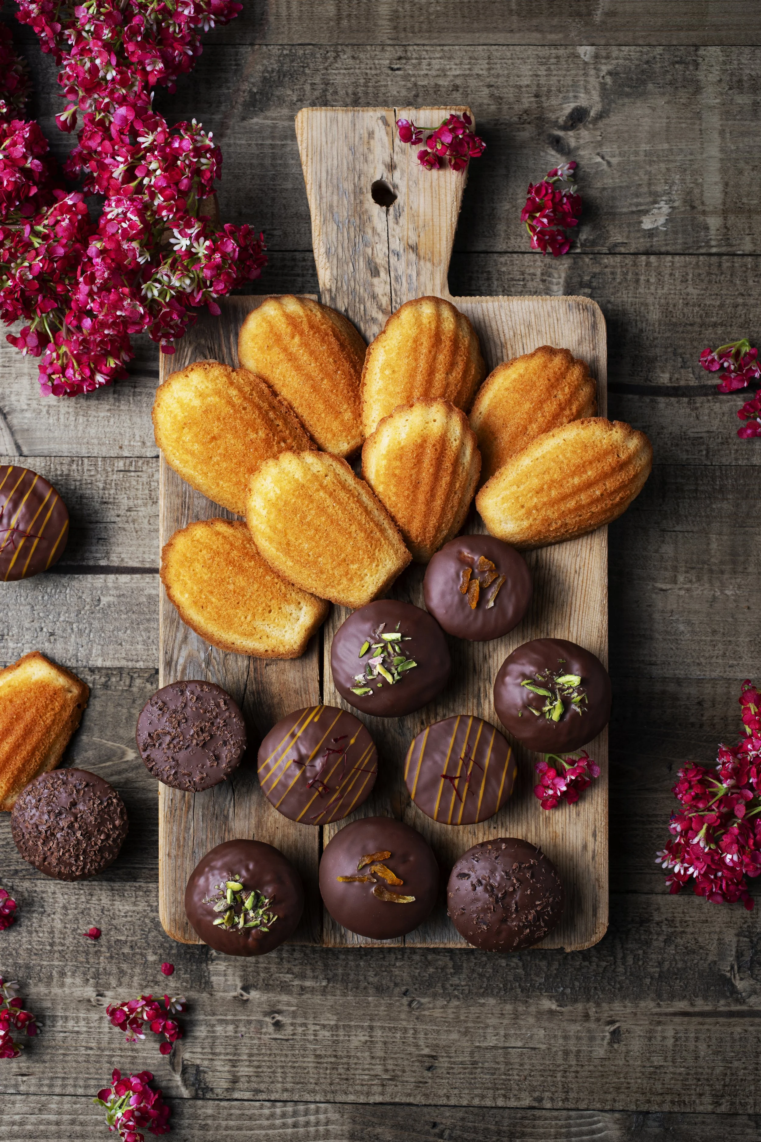 Assorted baked goods including madeleines and chocolate-covered cookies