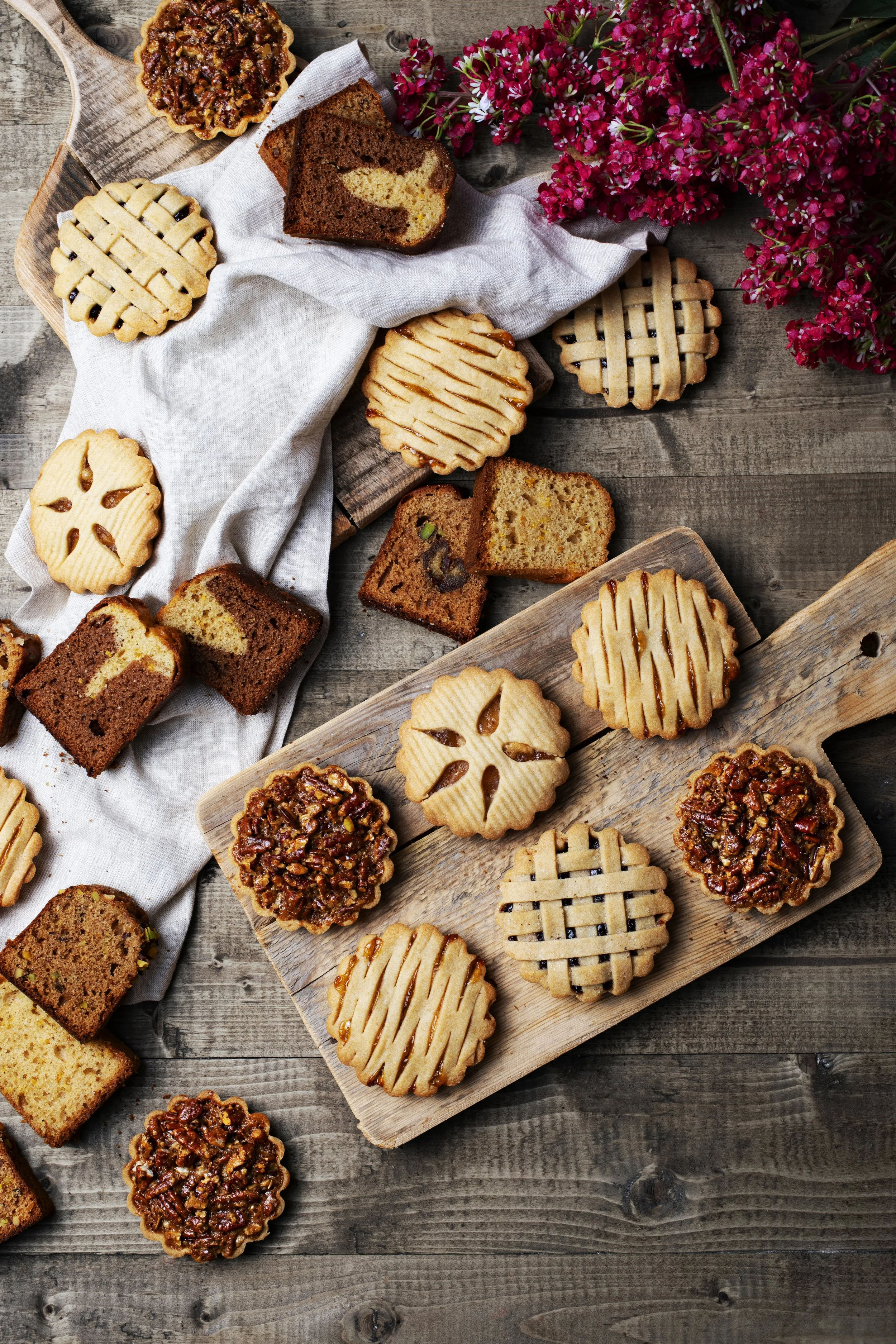 Assorted cookies and slices of cake on wooden platters