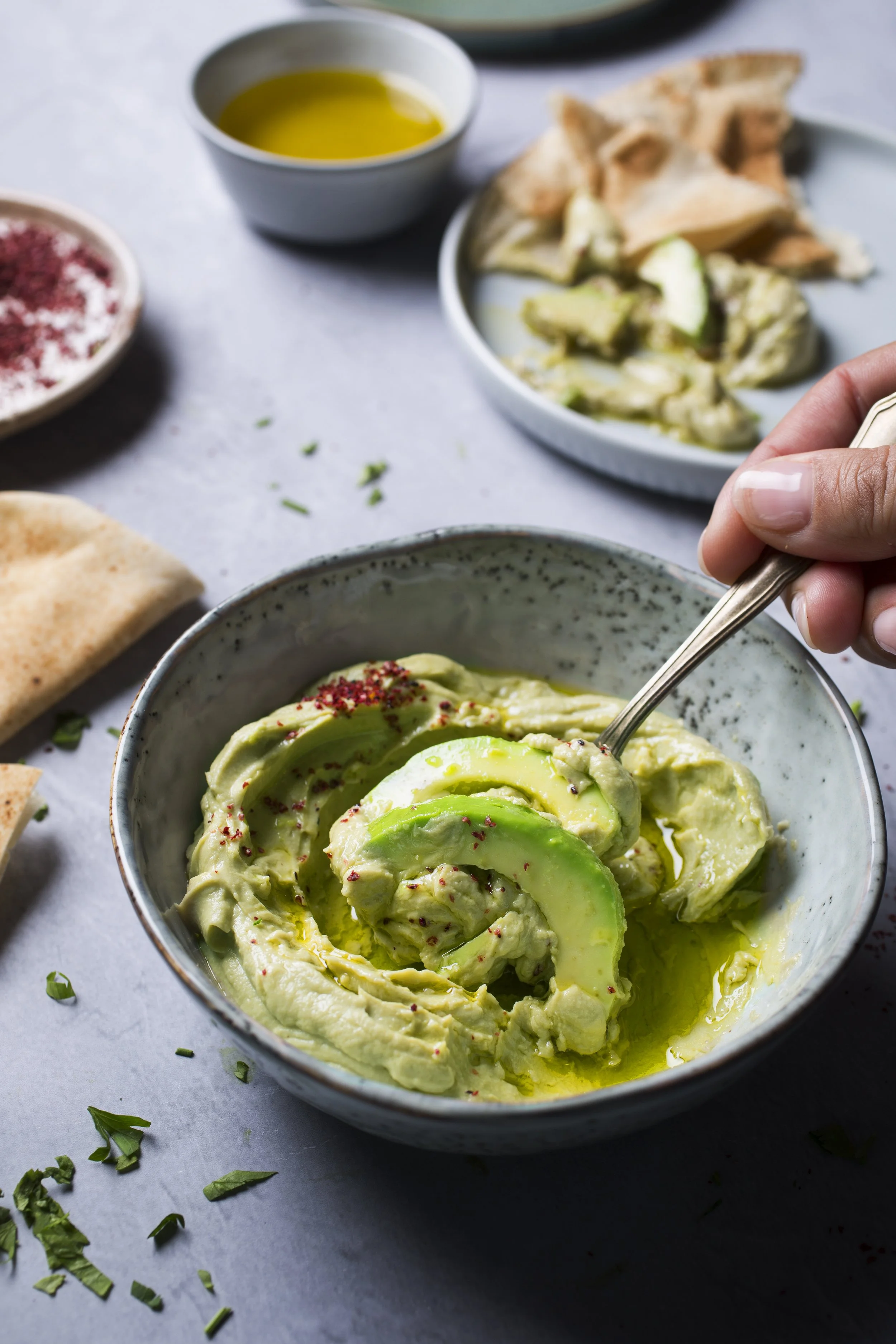A bowl of guacamole with sliced avocado