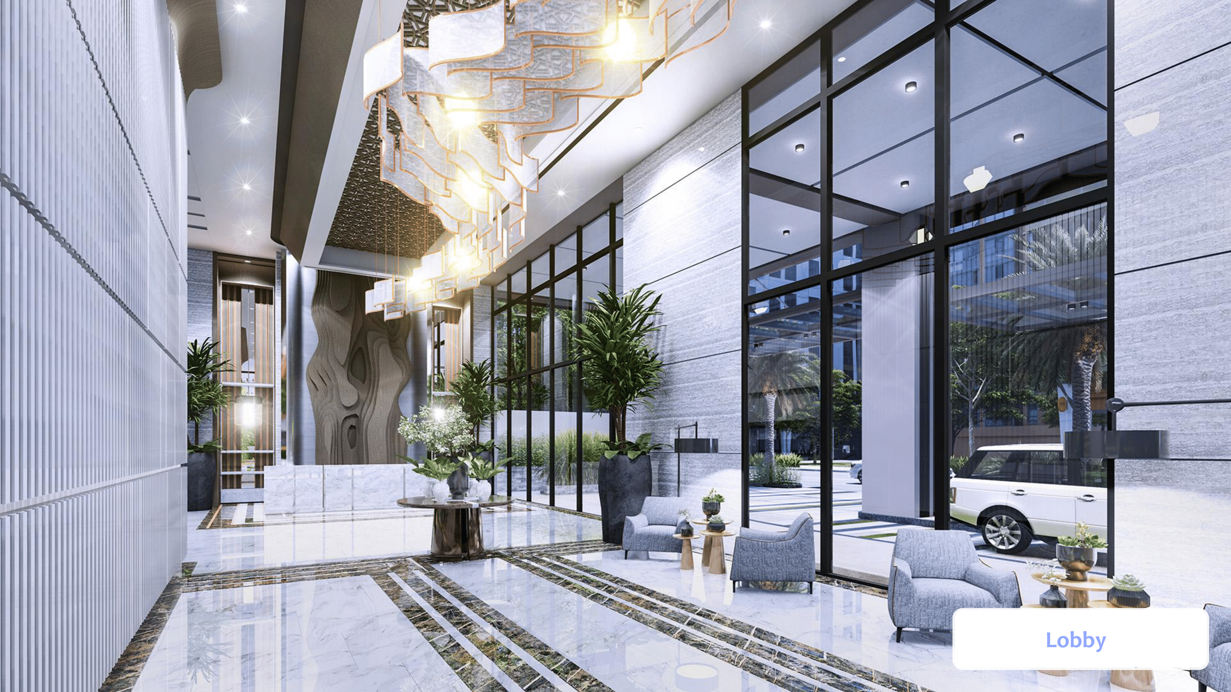 Lobby of a modern building with marble flooring, tall glass windows, and sleek furniture including armchairs and small tables. There are large potted plants, a decorative chandelier hanging from the ceiling, and a street scene visible through the windows outside.