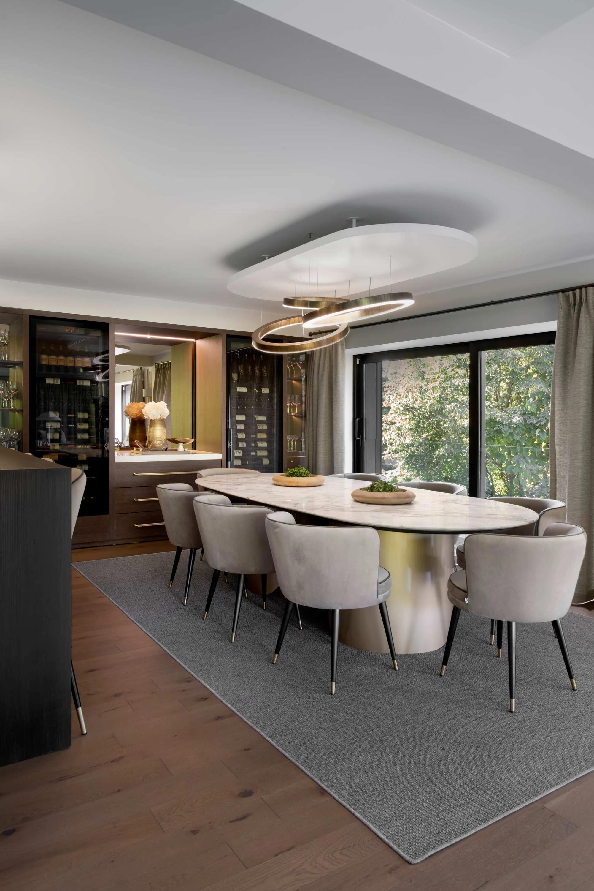 A bedroom with a bed featuring a lion plush toy and green blanket, wooden furniture, and a wall mural of jungle leaves and animals. An adult is standing near the door, and there's a loft with netting and a slide leading up, with blurred movement of a child on the slide.