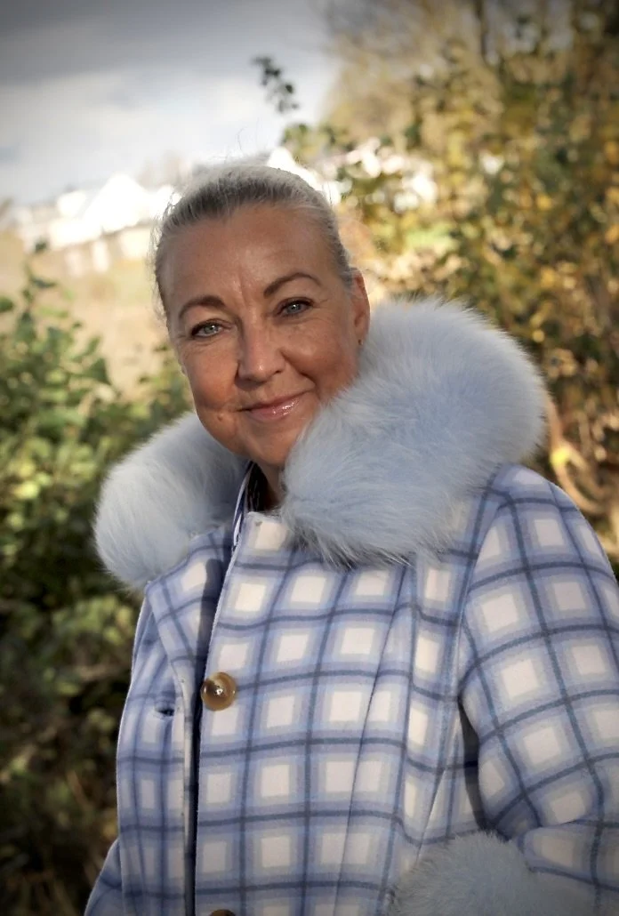 Kvinna utomhus i rutig kappa 