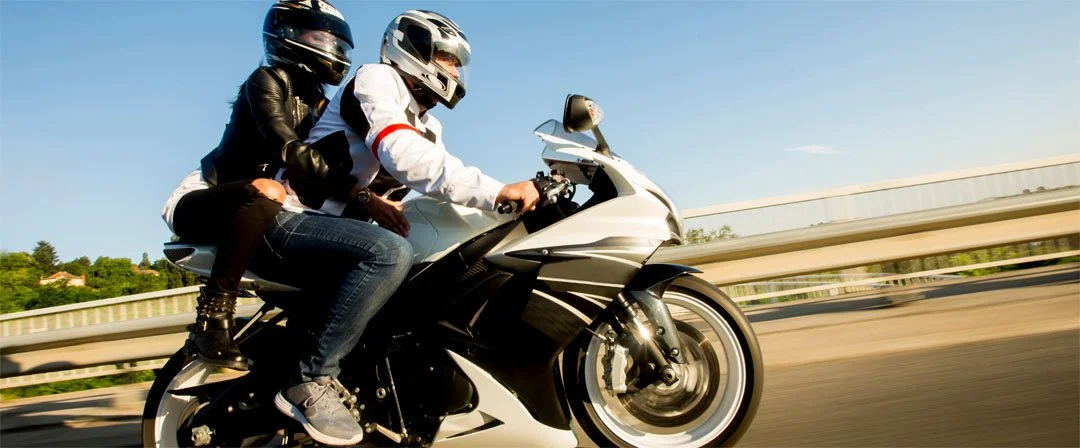 Foto von zwei Personen auf einem Motorrad fahrend