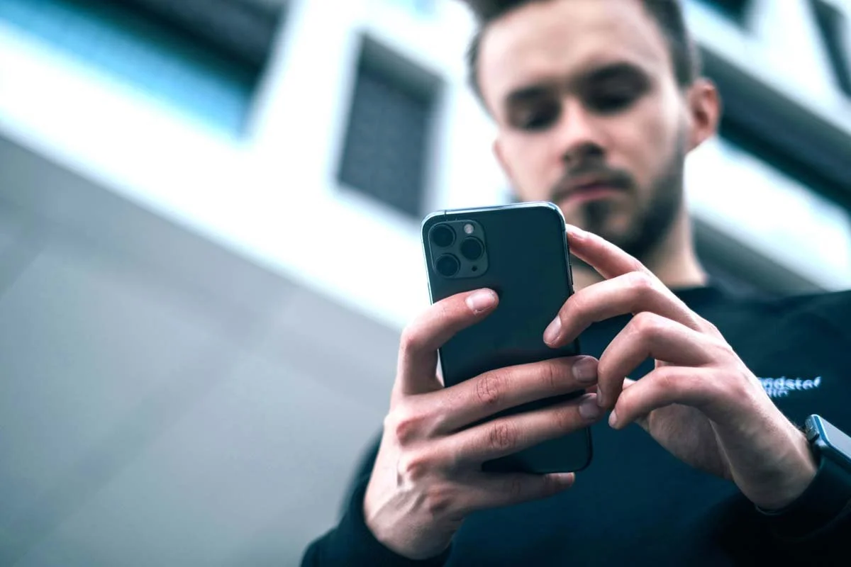 Foto eines Mannes mit einem iPhone in der Hand