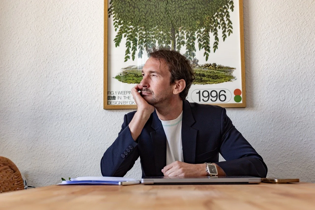 Thomas Ploch sitzend an einem Tisch, wie er über Berufsunfähigkeit nachdenkt