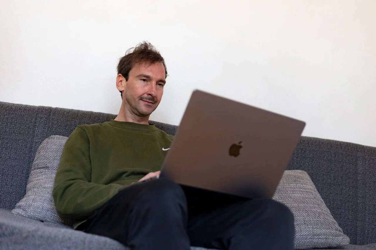 Thomas Ploch sitzend vor seinem Macbook