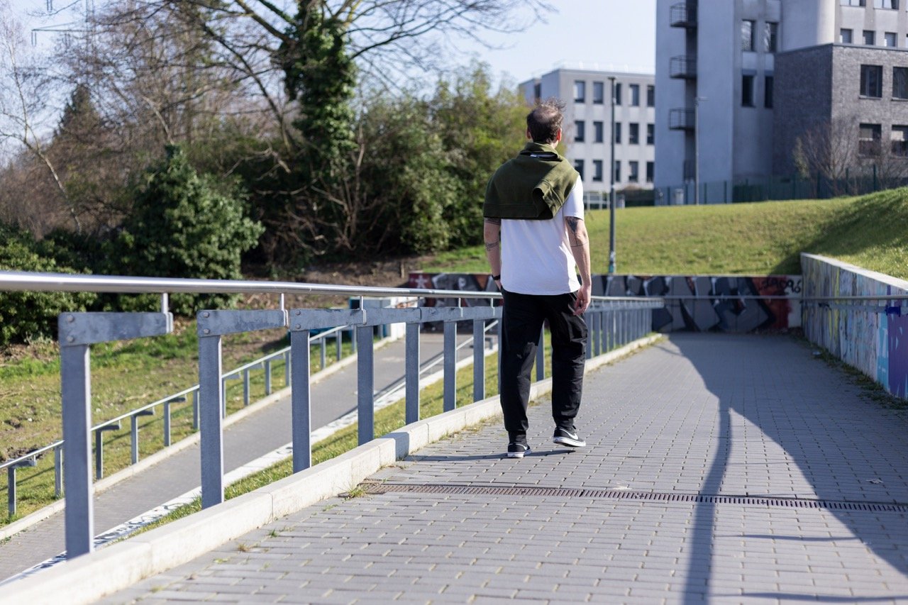Thomas Ploch, wie er einen Weg herunter läuft mit einem Pullover über den Schultern