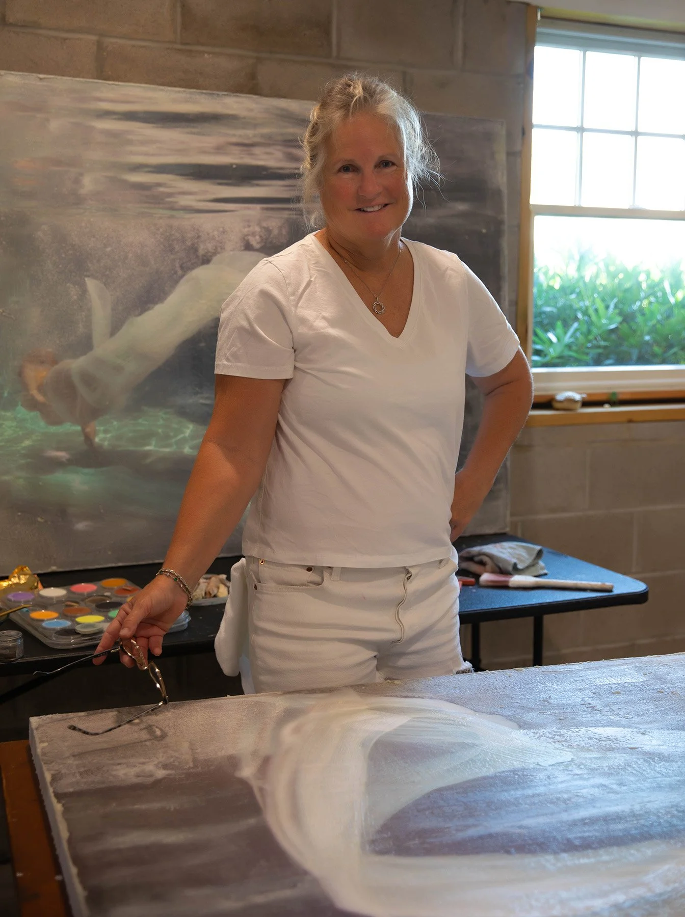 Susan J. Roche in her studio, surrounded by Saltwater Mythologies artwork and materials.