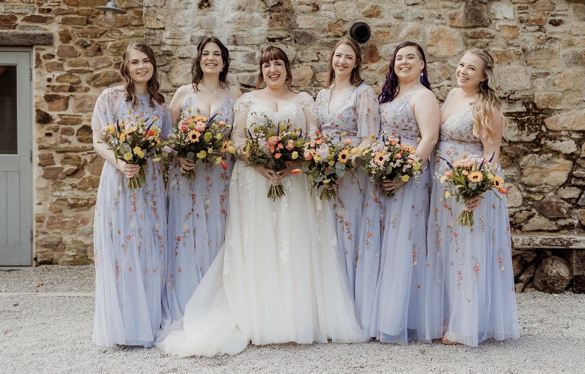 bride and her bridesmaids in floral dresses