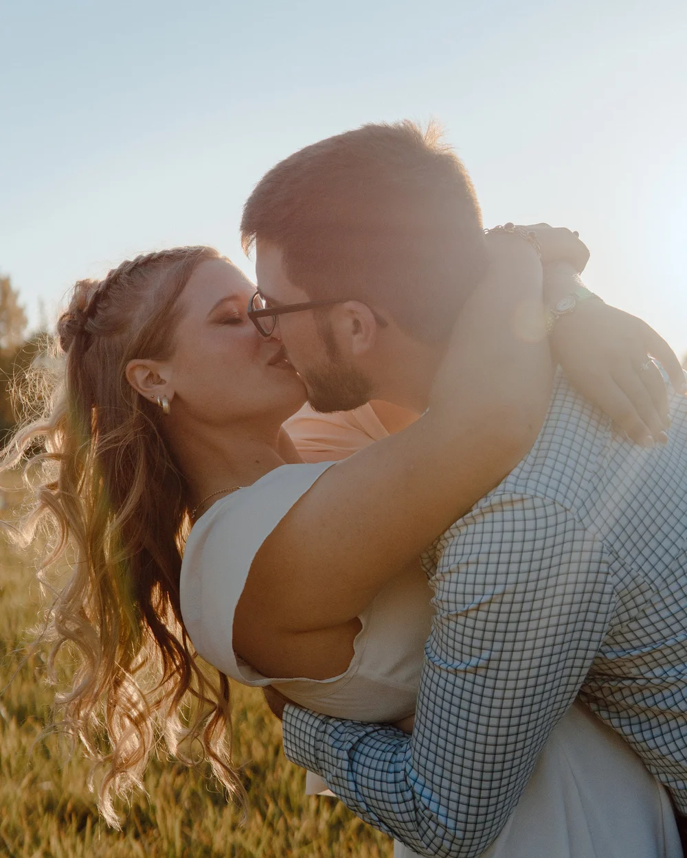 A couple kissing in golden afternoon light.