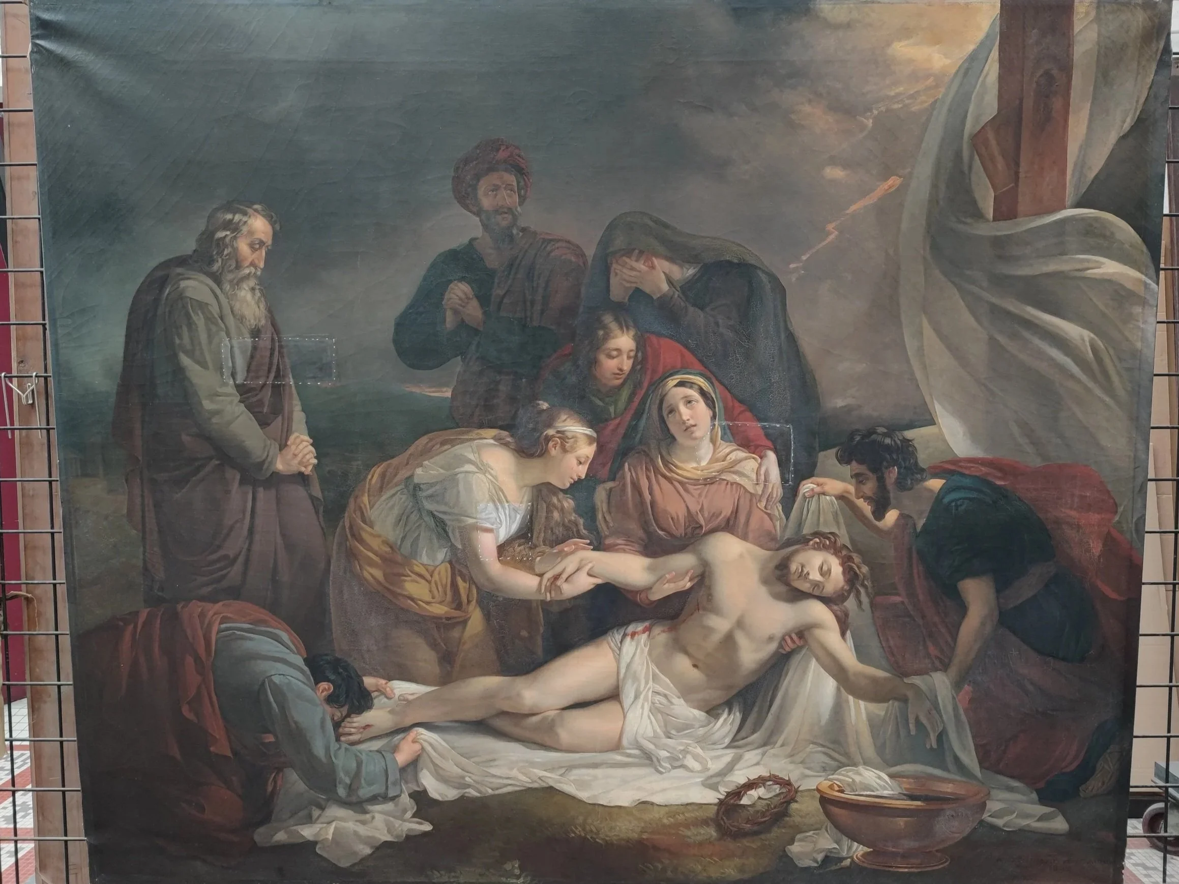 Une peinture représentant la dépouille du Christ entouré de plusieurs personnes, dont la Vierge Marie, Marie Madeleine, et des disciples, dans une scène dramatique et poignante.