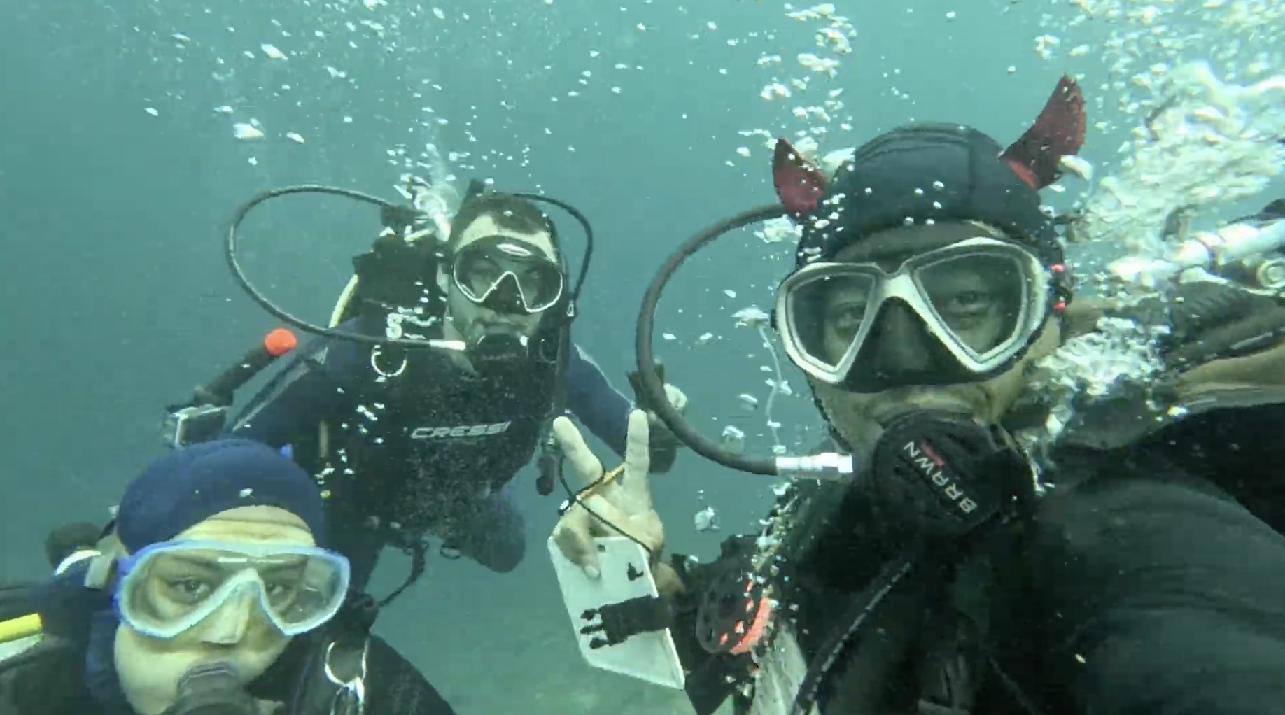 Yudi, Chansa and Simon smiling underwater