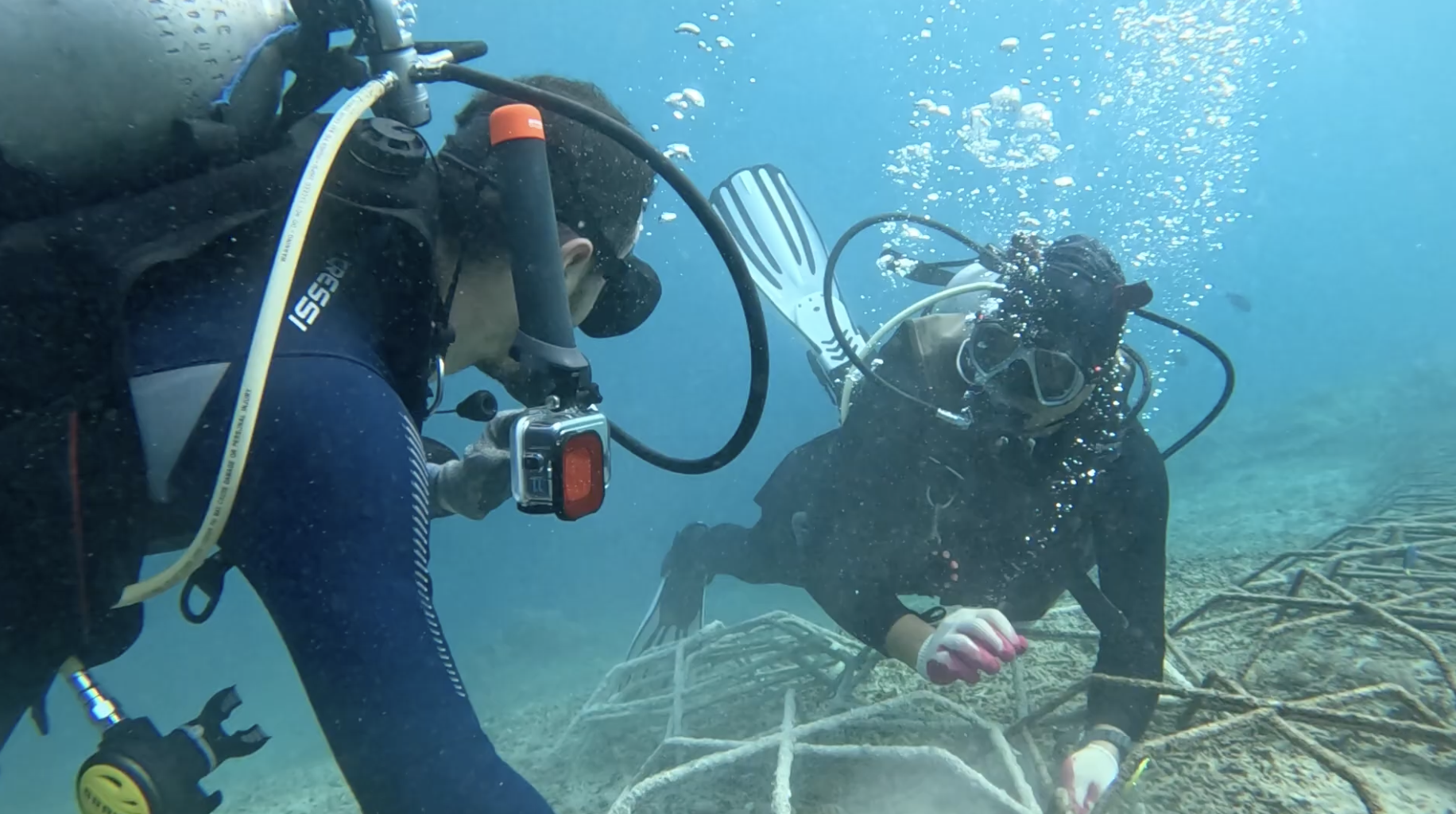 Yudi teaching Nico how to transplant corals underwater