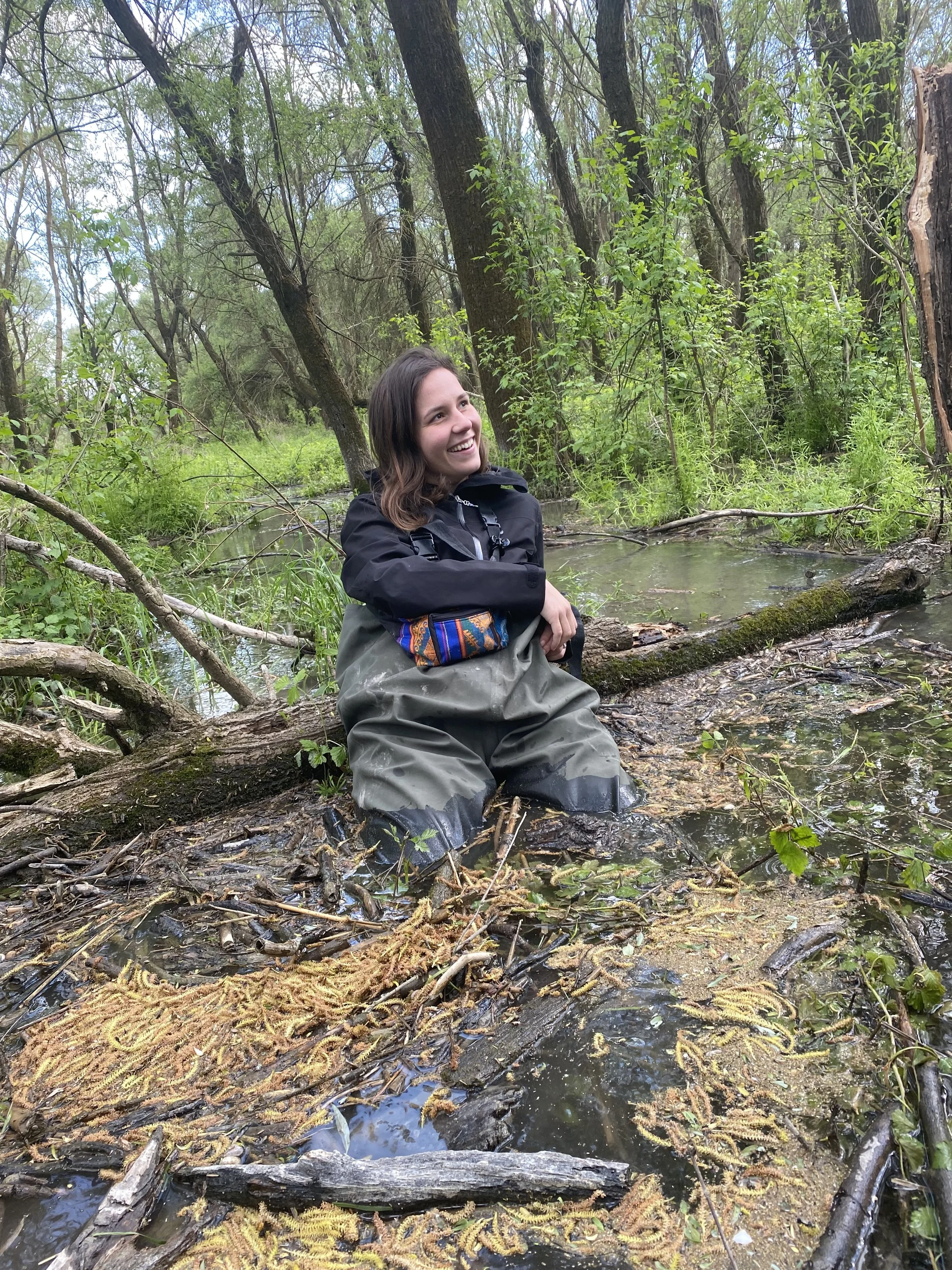 Adriana in waders in the flooded forest, with water up to her waist