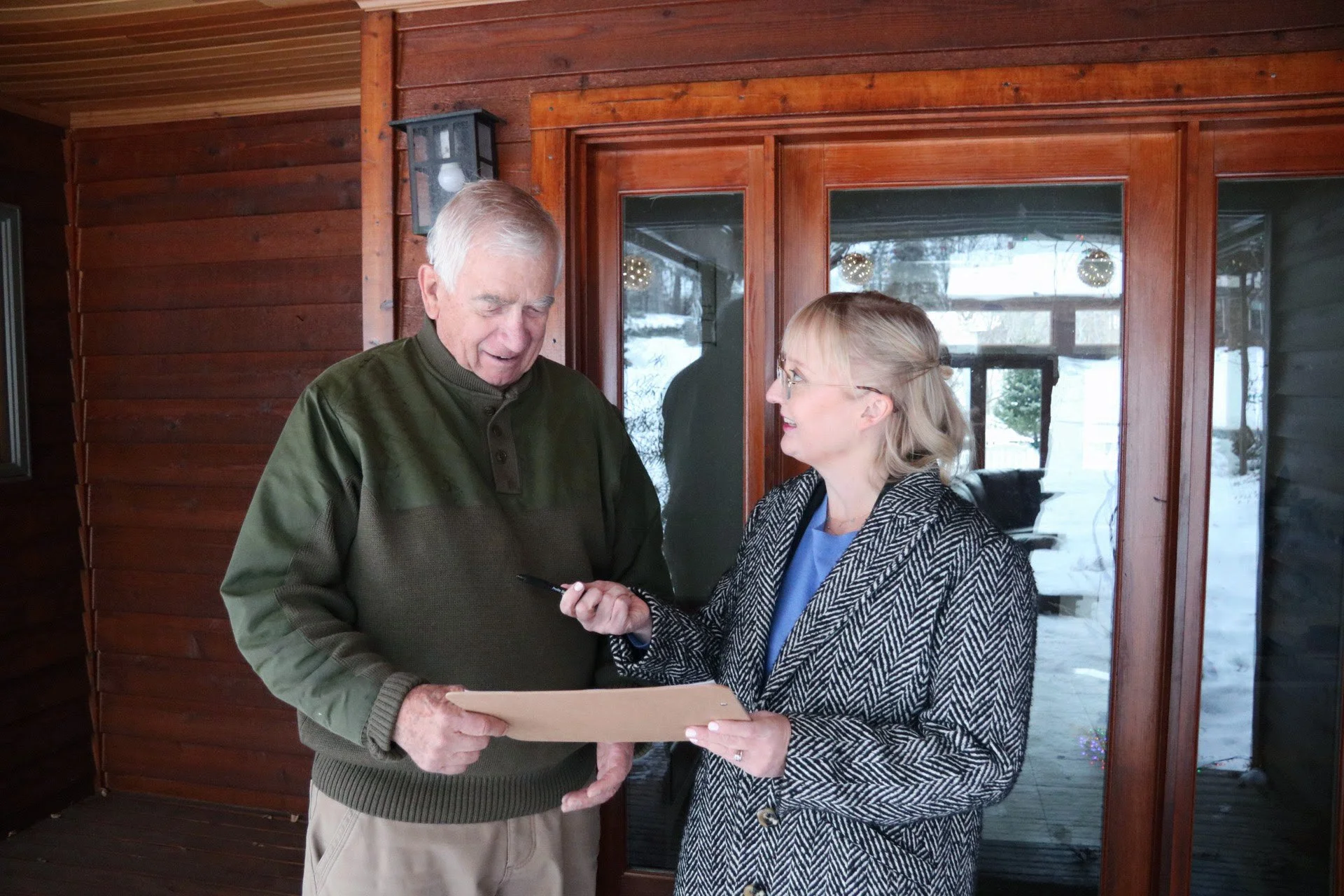 Candidate Aisha Elmquist looking at a document with an older man.