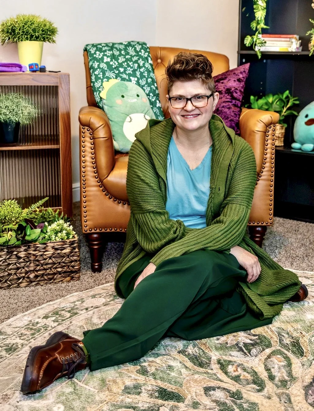 Devan Kennedy, queer and neurodivergent trauma therapist, seated in a warm space, providing EMDR and trauma therapy in Texas.