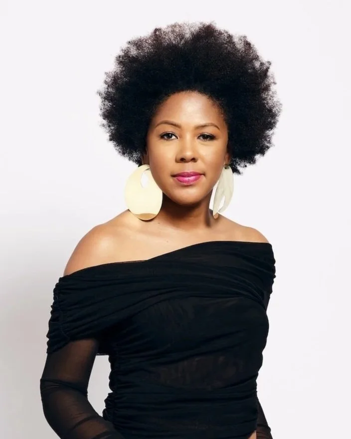 Tori Nichel wearing a black off shoulder top and gold statement earrings