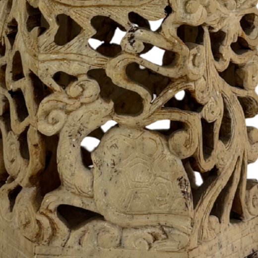 Carved decorative jade panel featuring a turtle with intricate swirling vines and branches surrounding it.
