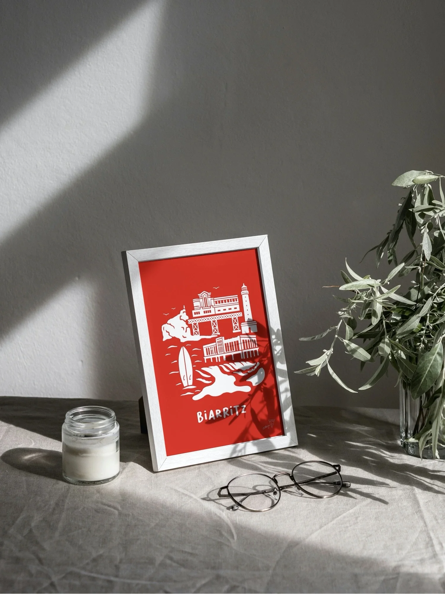 Affiche Biarritz encadrée dans un intérieur lumineux, illustration rouge et blanche de la ville basque