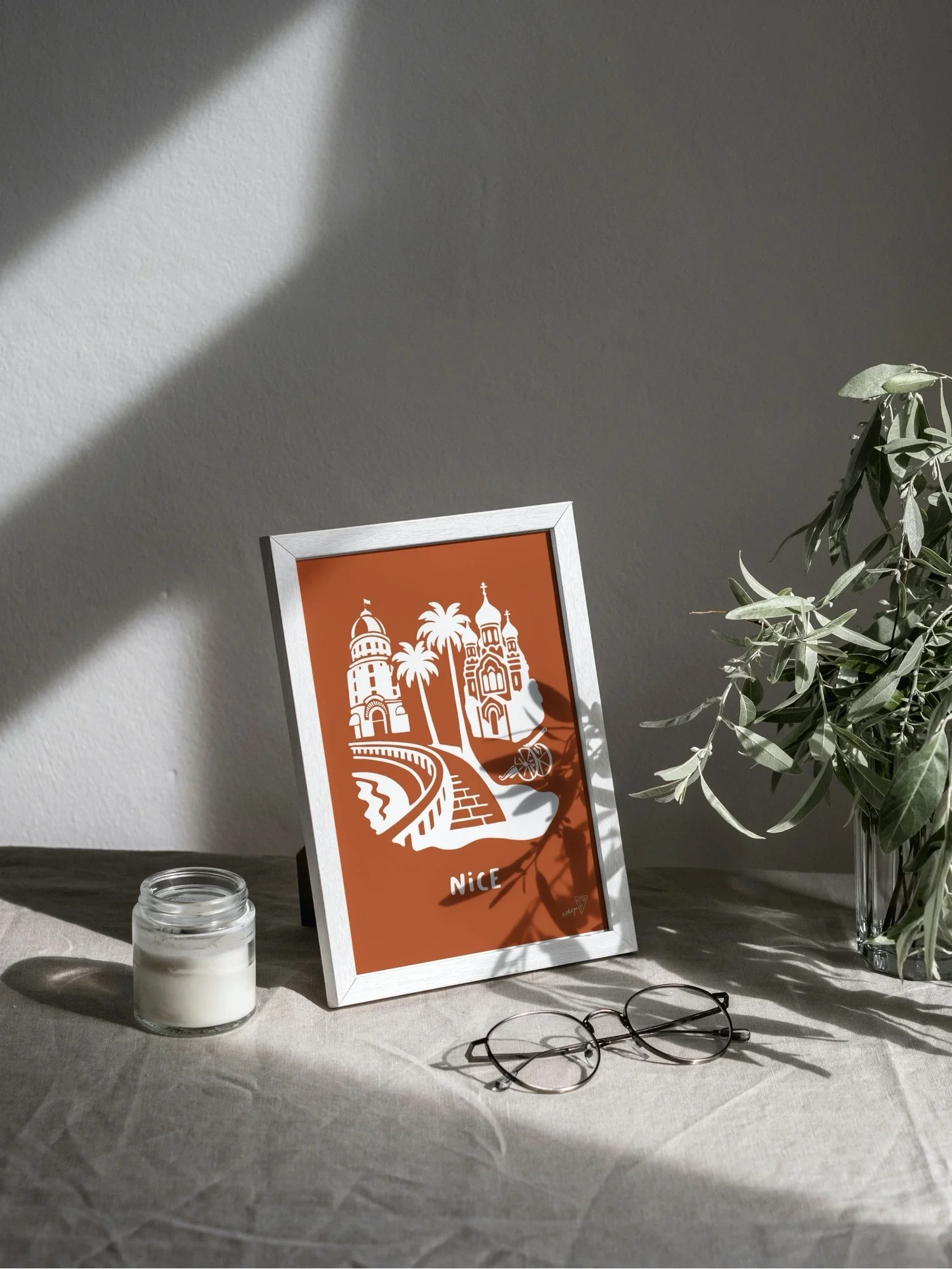 Affiche Nice encadrée dans un intérieur lumineux, illustration orange et blanche de la French Riviera