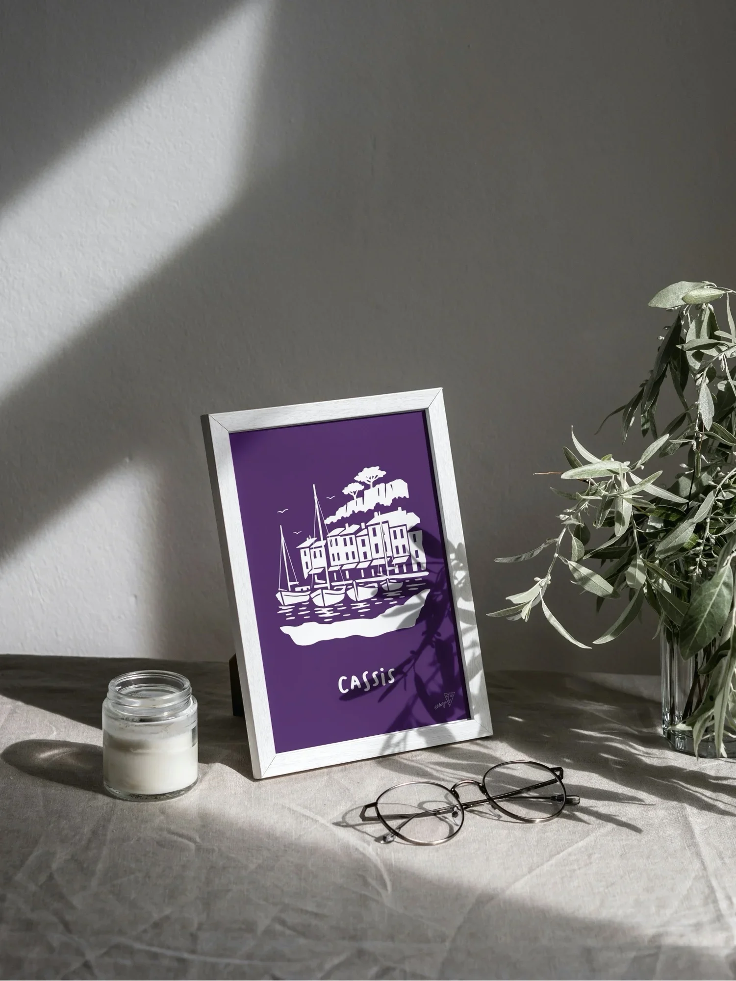 Affiche Cassis encadrée dans un intérieur lumineux, illustration violette et blanche de la région